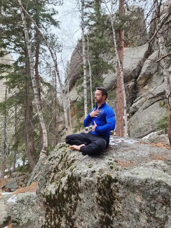 Travis Steffens practicing breathwork in the mountains