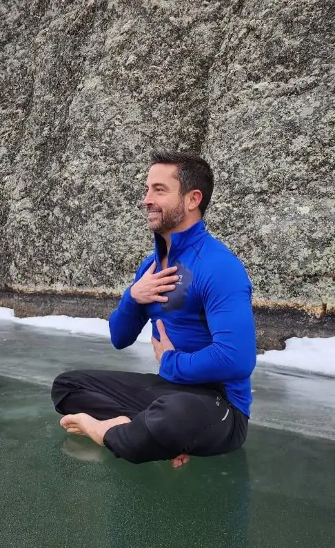 Seated breath practice on frozen lake, hand on heart