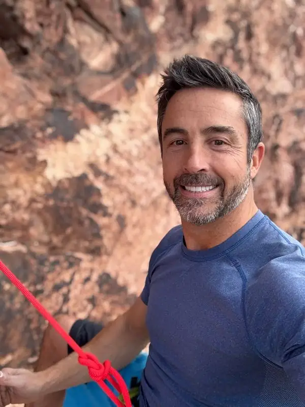 Smiling climbing selfie with red rope on red rock