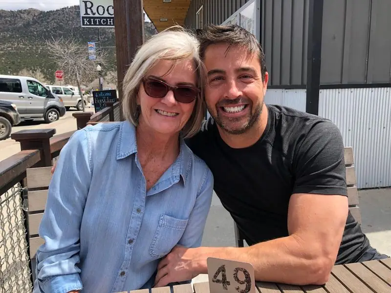 Smiling with mother at cafe patio table