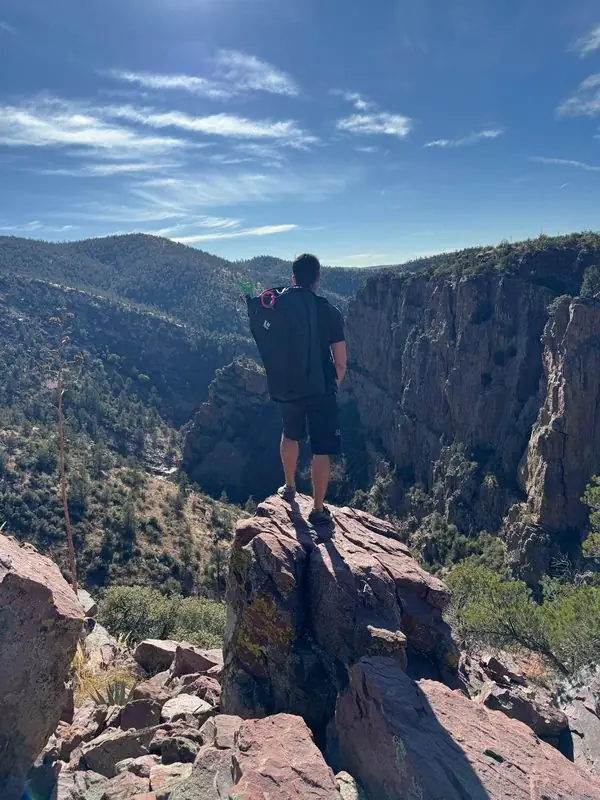 Standing on rocky pinnacle overlooking deep canyon