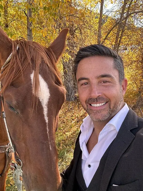 Selfie with horse among golden autumn foliage