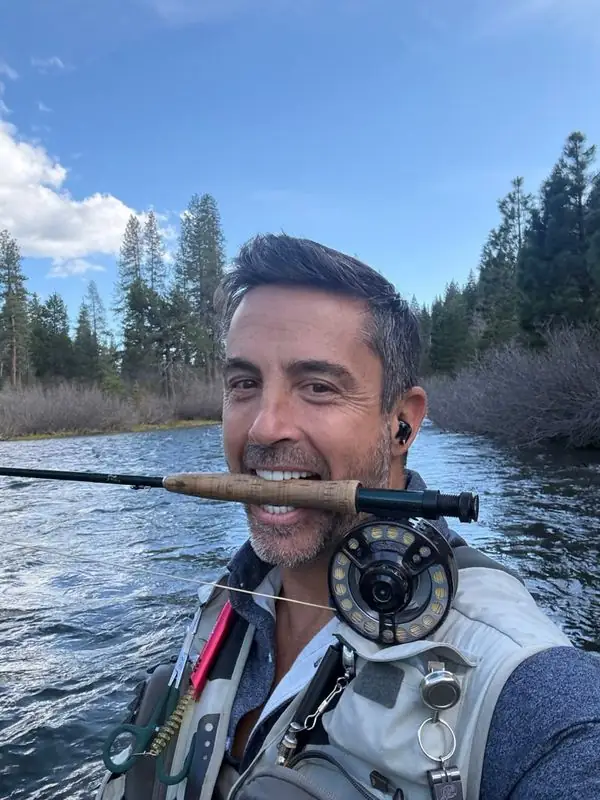 Fly fishing selfie, rod in teeth, riverside