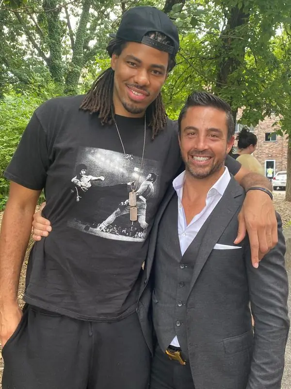 Posed with tall friend outdoors, gray suit vest