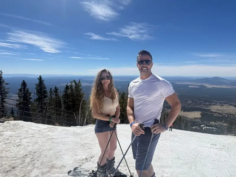 Travis and partner spring skiing on sunny summit