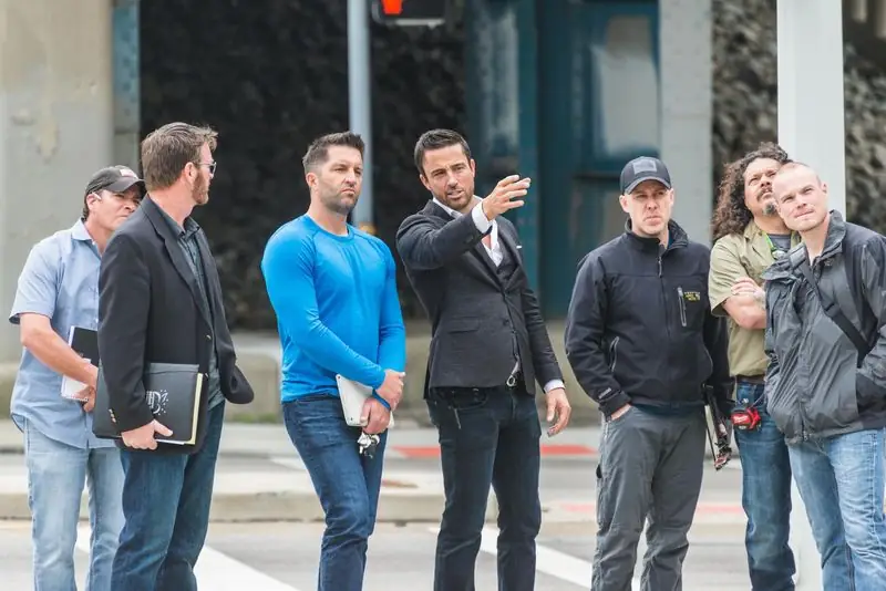 Travis in suit gesturing to group during site walkthrough