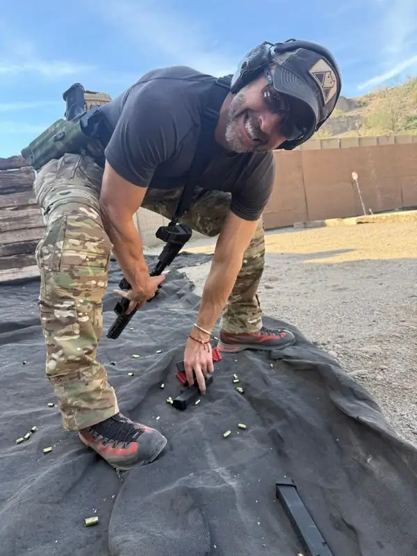 Travis in camo grabbing pistol mags at shooting range
